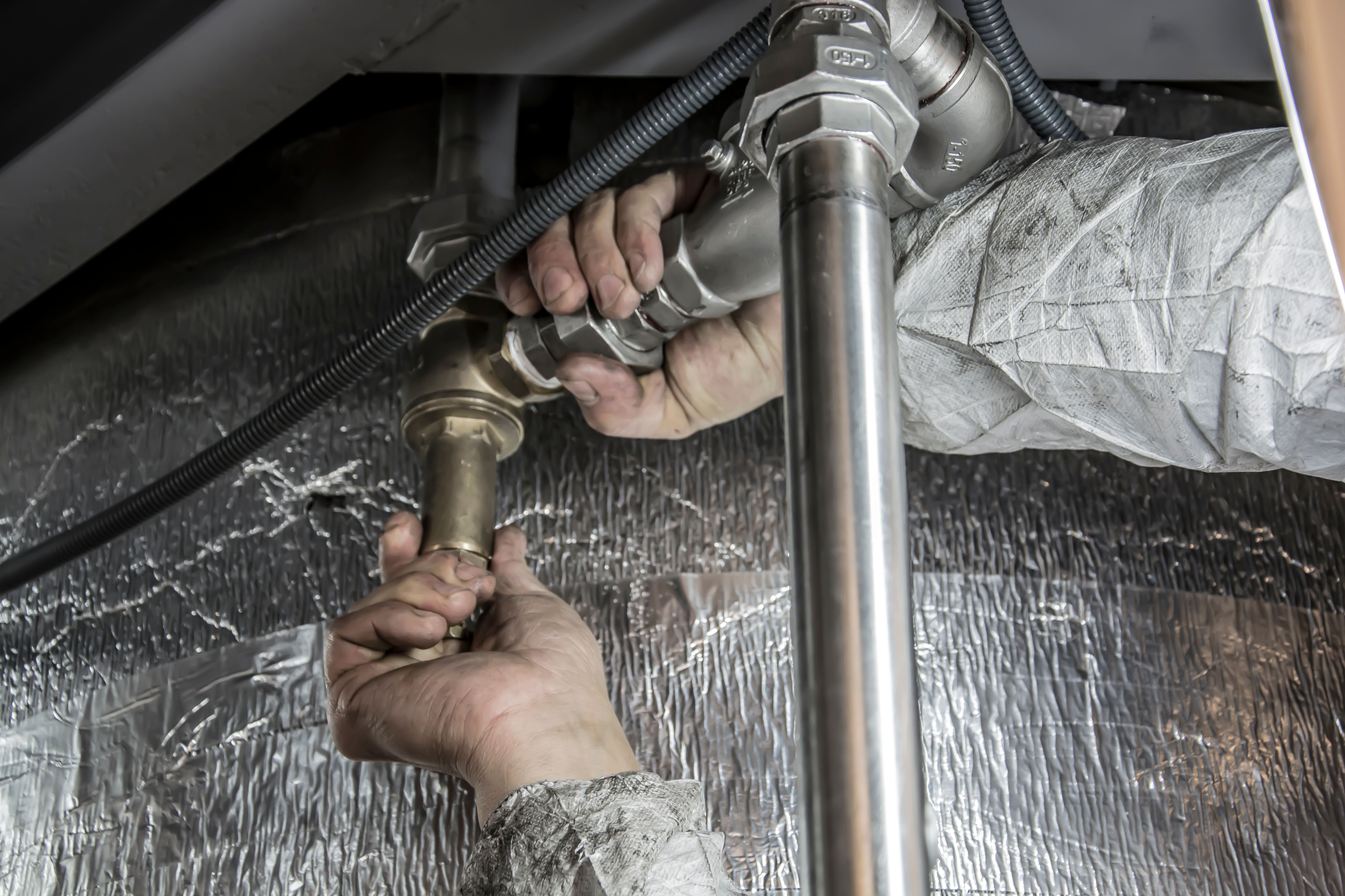 Plumber working on pipe fittings
